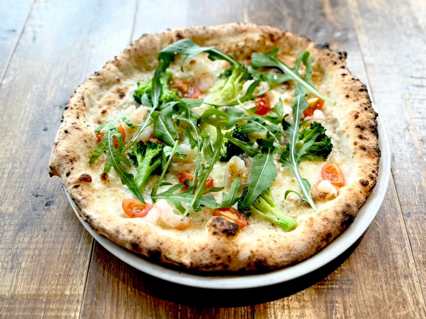Shrimp, cherry tomatoes, broccoli and cheese pizza with anchovy