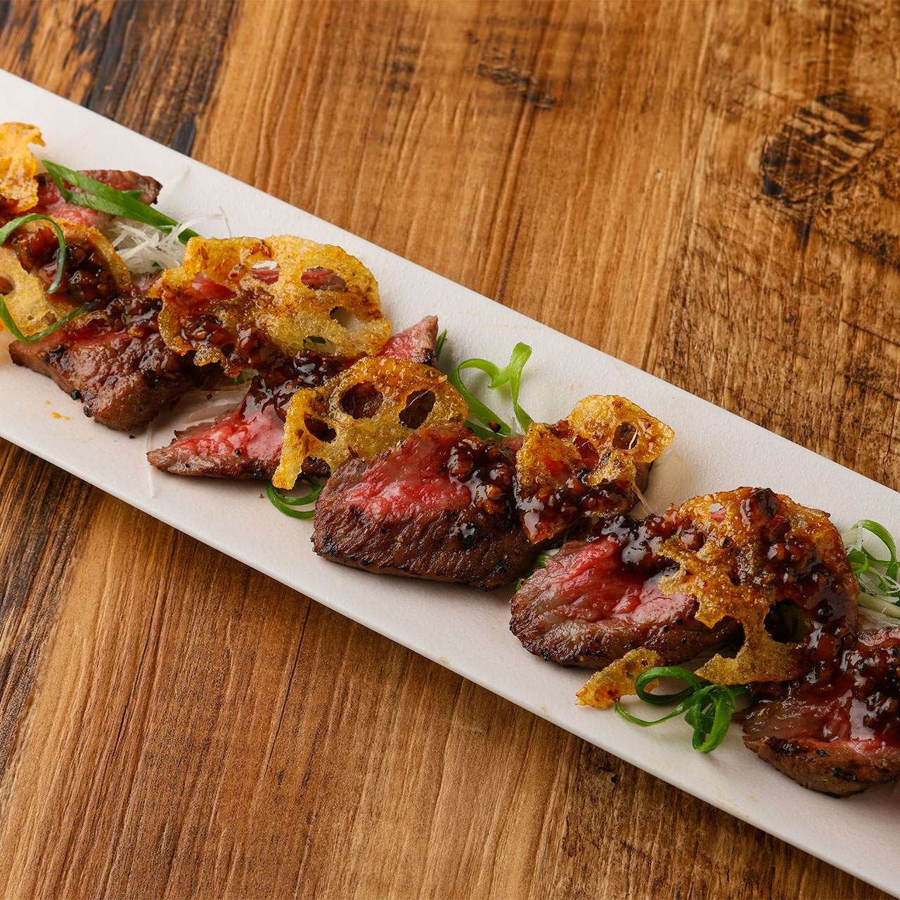 和牛の炙りきんぴら蓮根　有馬山椒と大葉のソース