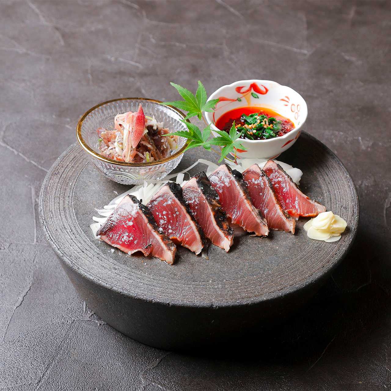 用稻草烤制的鲣鱼，配以大蒜、韭菜酱油和秋季茗荷