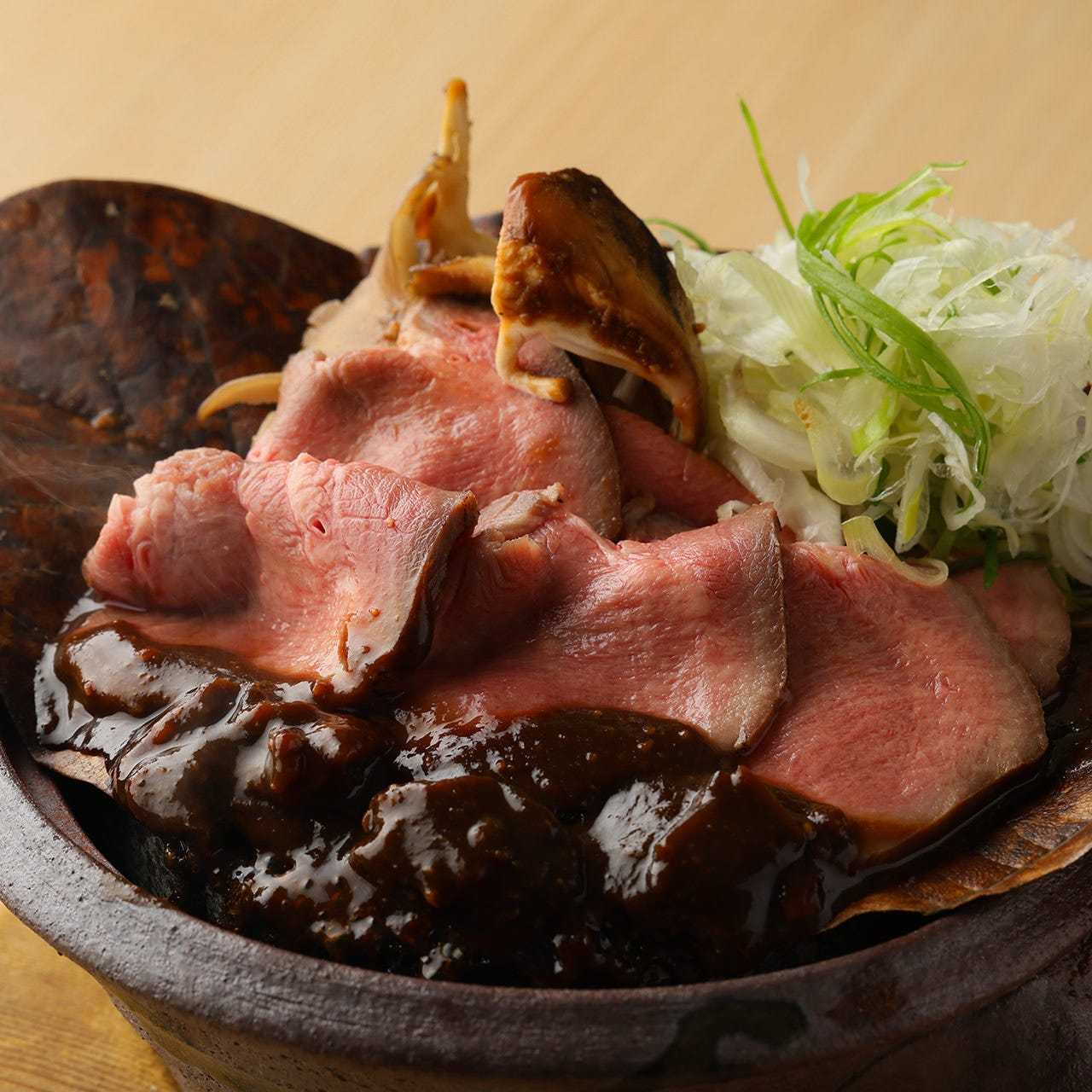Beef tongue and mushrooms grilled on a magnolia leaf