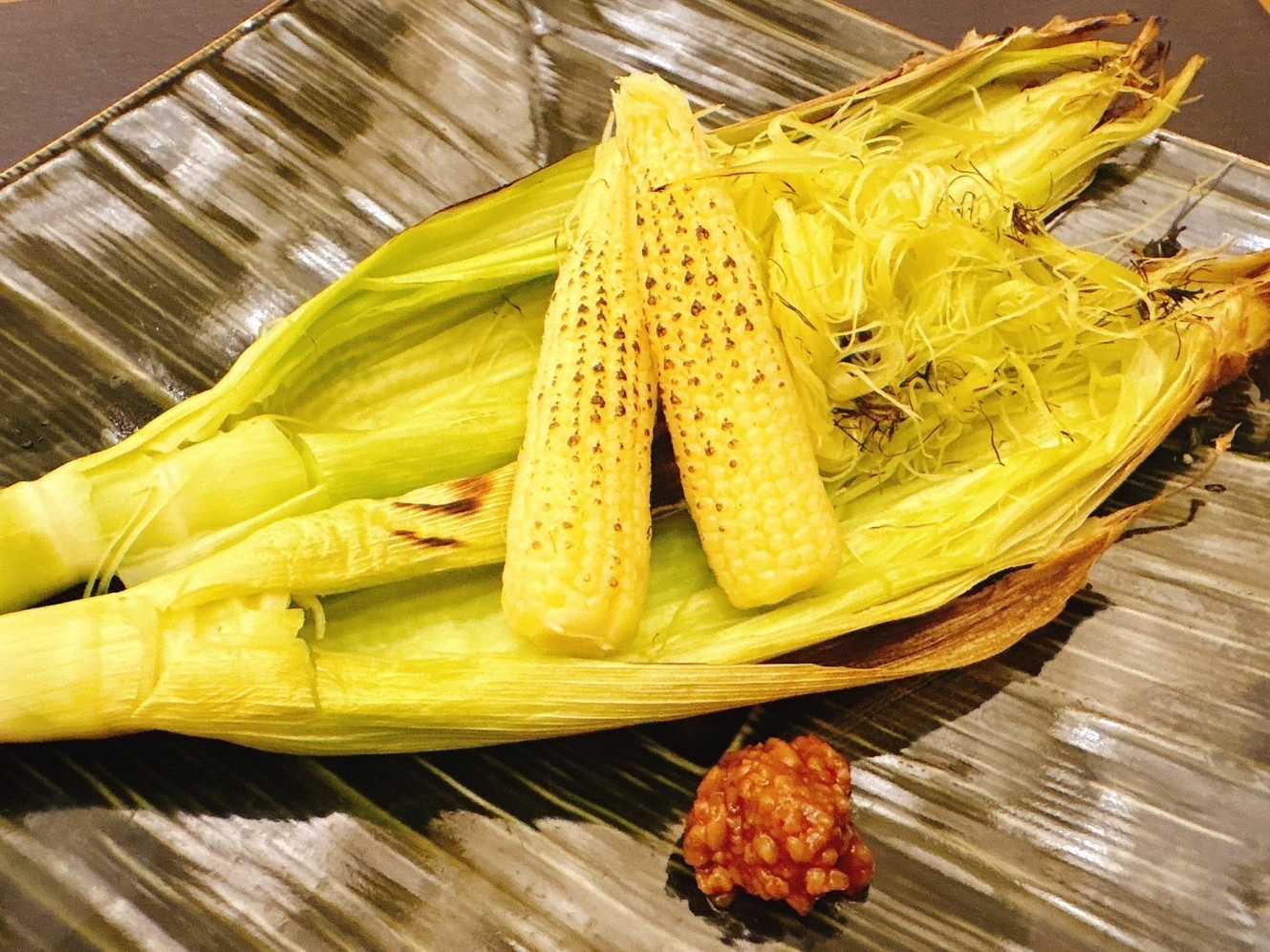Charcoal grilled young corn with husk